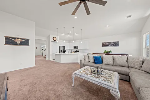 a view of a kitchen with wooden floor and white cabinets