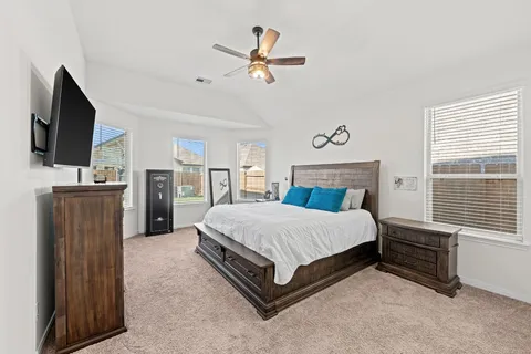 a spacious bedroom with a bed and a ceiling fan