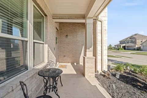 a view of a balcony with table and chairs and potted plants