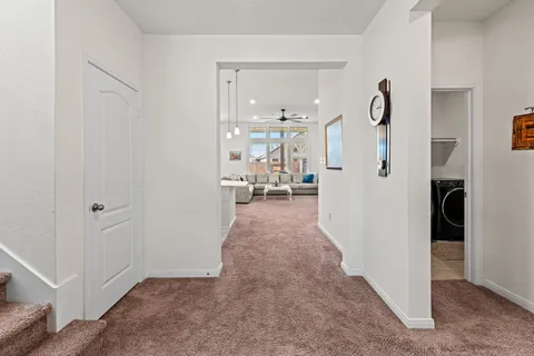 a living room with furniture a refrigerator and kitchen view