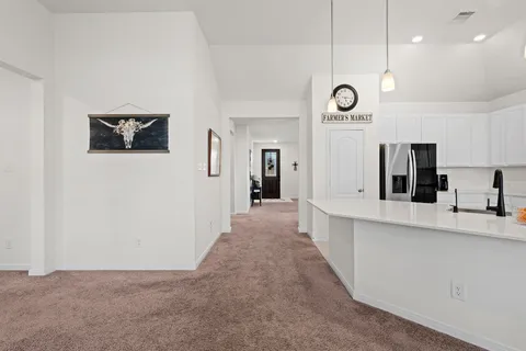 a kitchen with stainless steel appliances kitchen island granite countertop a sink a stove a dining table and chairs with wooden floor