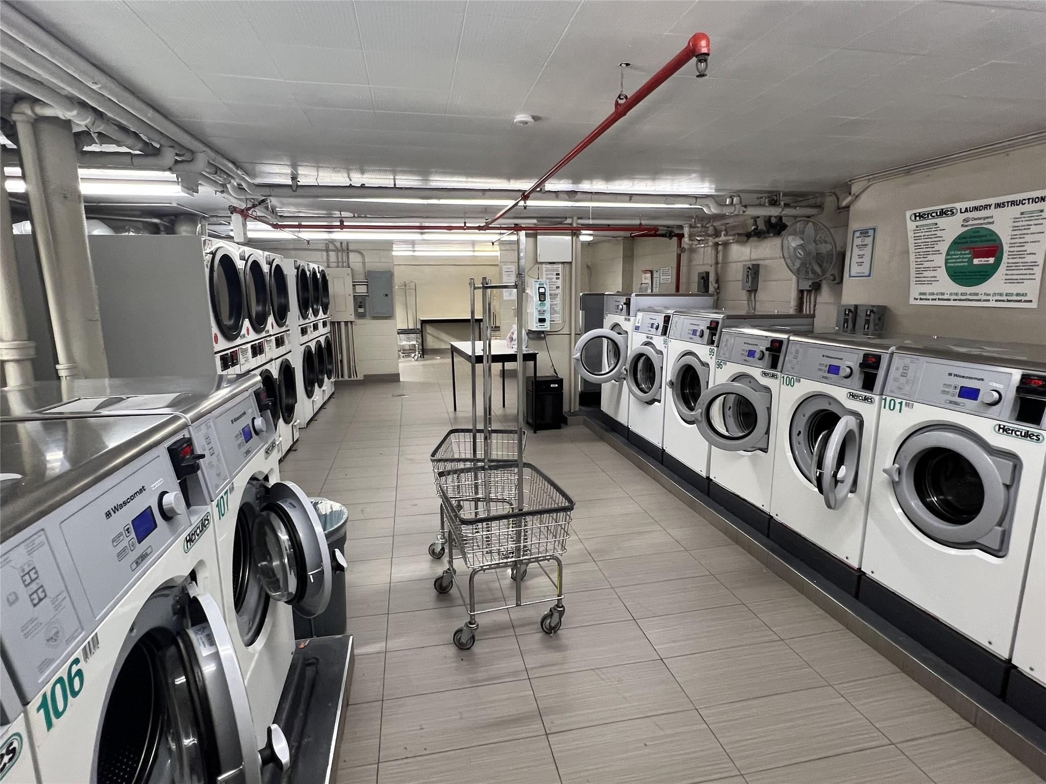77 Fulton Street, Unit 2J Manhattan, NY 10038 - Photo 18 of 20 a utility room with multiple dryer and washer
