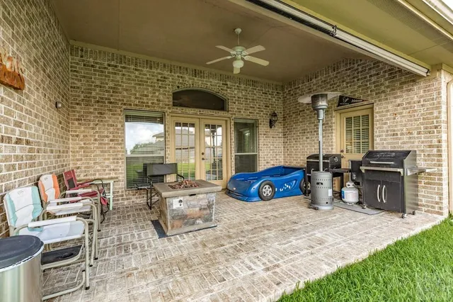 a view of a patio with table and chairs potted plants and a barbeque