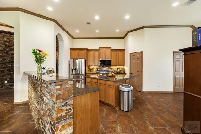 a kitchen with stainless steel appliances granite countertop a sink stove and refrigerator