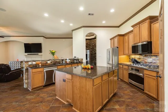 a kitchen with stainless steel appliances a sink stove and refrigerator
