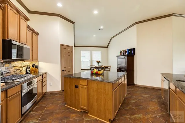 a kitchen with stainless steel appliances granite countertop a stove microwave and refrigerator