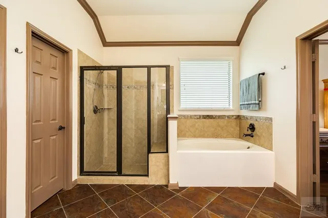 a bedroom with a bed and dresser with wooden floor