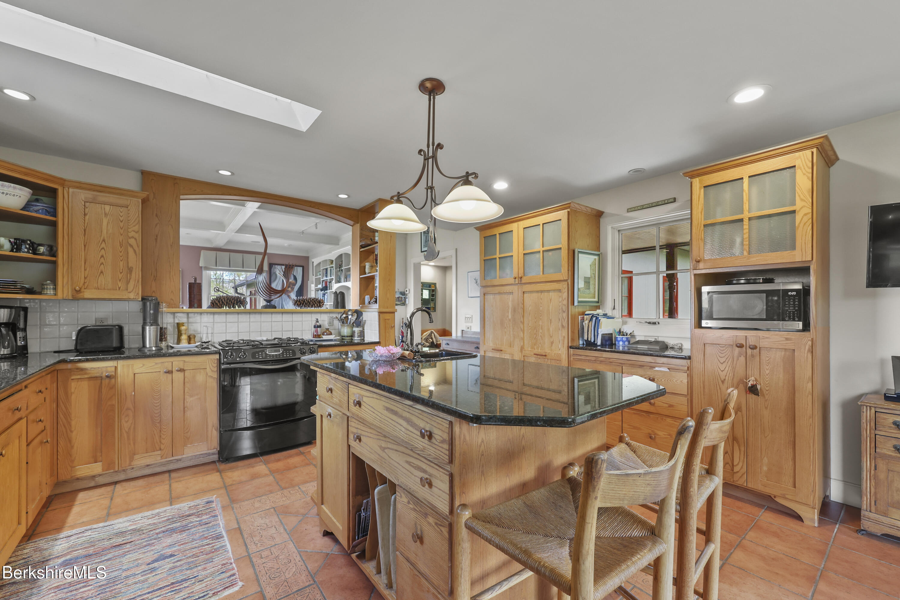 821 Pattison Road North Adams, MA 01247 - Photo 27 of 68 a kitchen with stainless steel appliances granite countertop a stove top oven a sink dishwasher a dining table and chairs with wooden floor