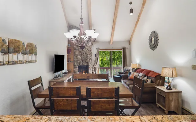 a living room with furniture a chandelier and a flat screen tv