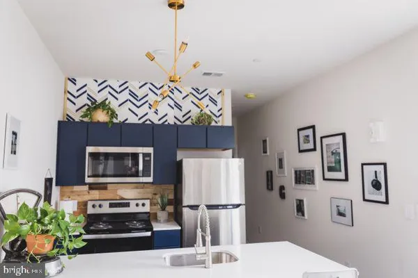 a kitchen with stainless steel appliances a stove a refrigerator and a sink