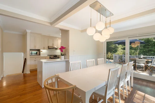 a kitchen with stainless steel appliances granite countertop a stove a sink dishwasher a dining table and chairs with wooden floor