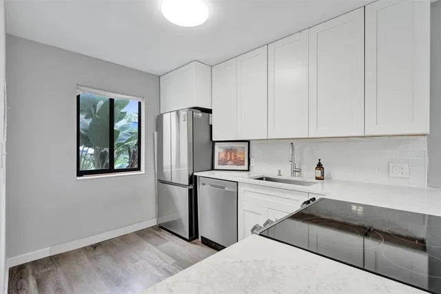 a view of an empty room with wooden floor and a ceiling fan