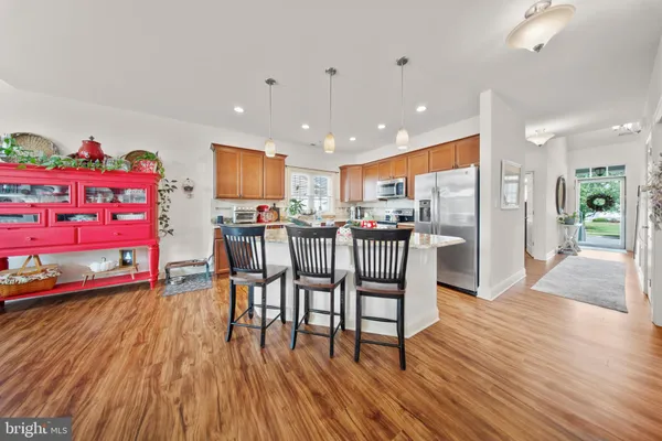 an open kitchen with wooden floor and stainless steel appliances