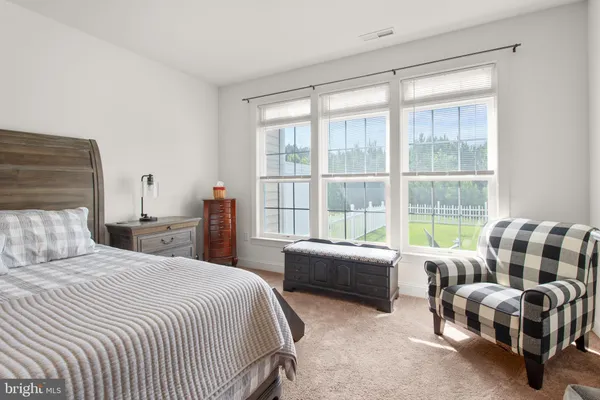 a bedroom with a bed and a couch next to a window