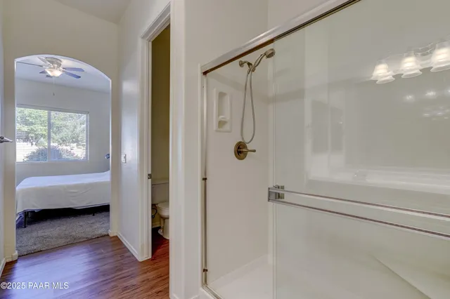a bathroom with a tub shower view and windows