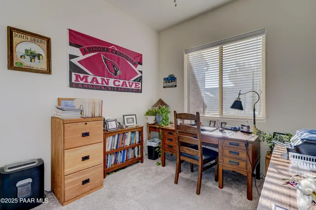 a view of a workspace with furniture and a window