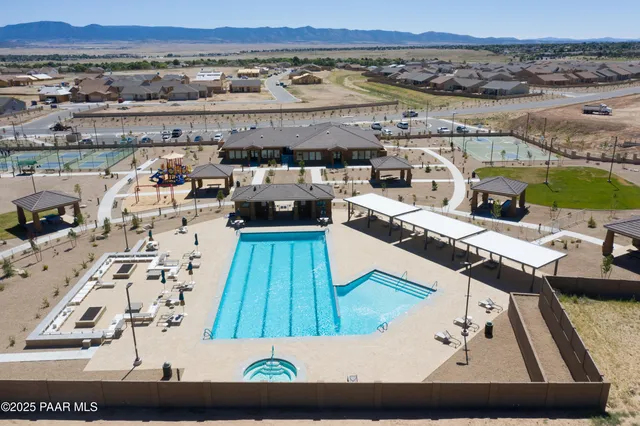 a view of a white house with large windows and a table and chairs