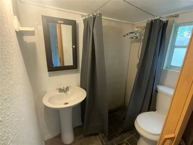 a bathroom with a sink toilet and shower a mirror