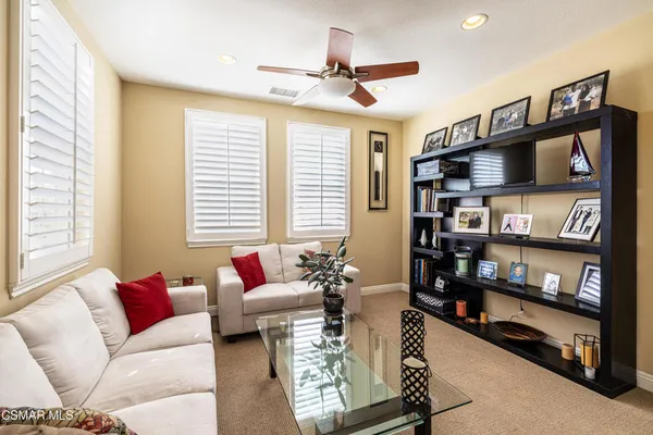 a living room with furniture a bookshelf and a window