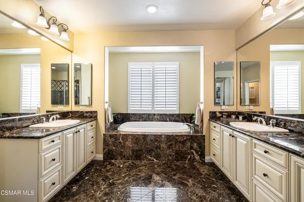 a spacious bathroom with double vanity and a bathtub