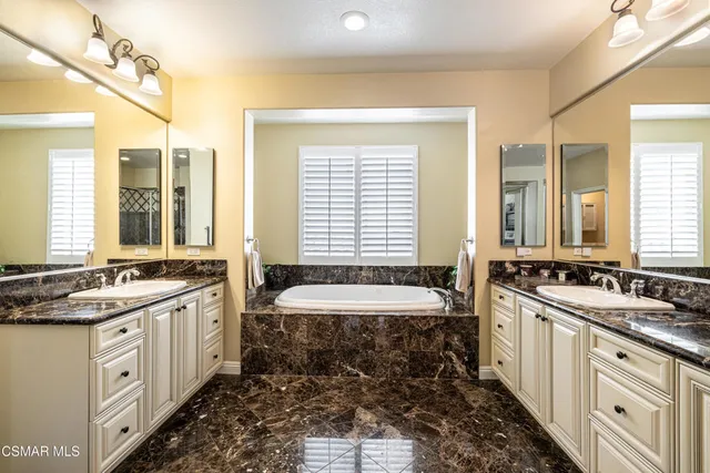 a spacious bathroom with double vanity and a bathtub