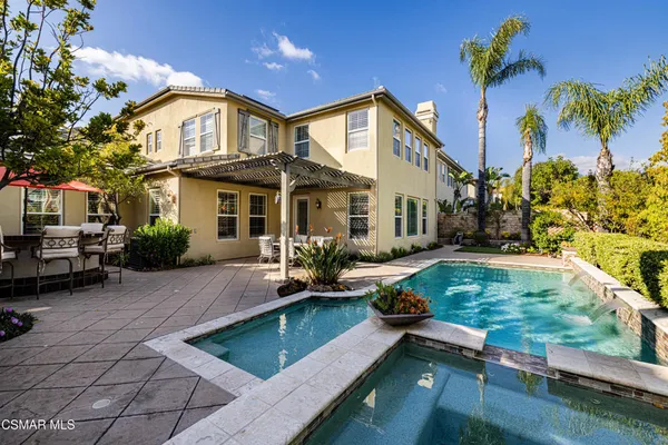 a view of a house with pool and sitting area
