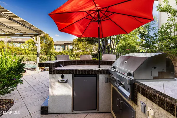 a patio with a table and chairs under an umbrella