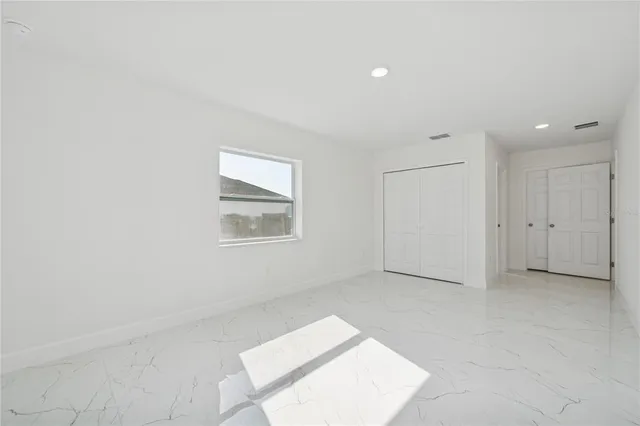 an empty room with a white cabinet and door