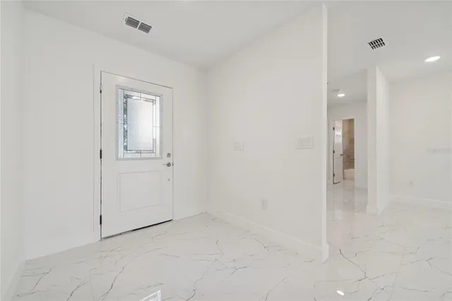 an empty room with white cabinet and mirror
