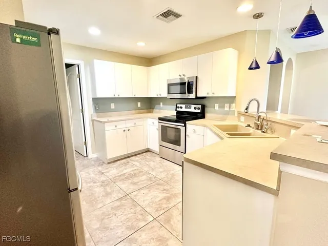 a kitchen with stainless steel appliances a refrigerator sink and microwave
