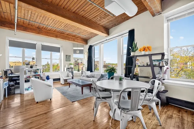 a living room with fireplace furniture and a large window