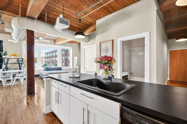 a kitchen with stainless steel appliances a sink a counter space and wooden floor