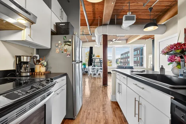 a kitchen with stainless steel appliances kitchen island granite countertop a stove and cabinets
