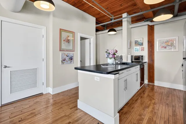 a kitchen with granite countertop a white stove top oven and wooden floor