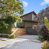 a front view of a house with a yard and tree