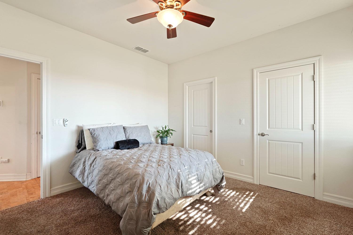 6120 Eschinger Road Elk Grove, CA 95757 - Photo 14 of 39 a bedroom with a bed and a chandelier