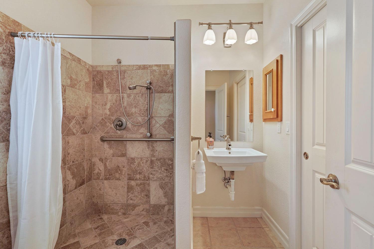 6120 Eschinger Road Elk Grove, CA 95757 - Photo 15 of 39 a bathroom with a shower a mirror and a sink