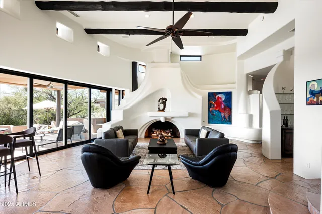 a living room with furniture a fireplace and a floor to ceiling window