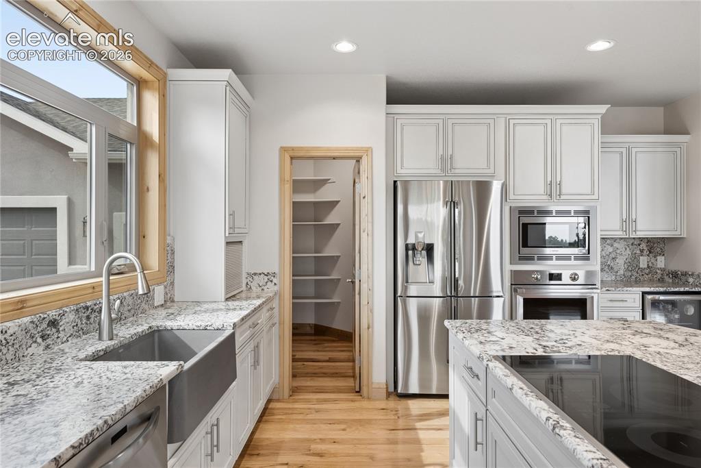 10840 Vollmer Road Colorado Springs, CO 80908 - Photo 20 of 49 a kitchen with stainless steel appliances granite countertop a sink stove and refrigerator