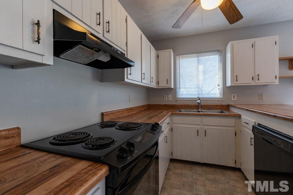 2437 Tusket Court Raleigh, NC 27613 - Photo 11 of 30 a kitchen with stainless steel appliances a stove a sink dishwasher and cabinets with wooden floor