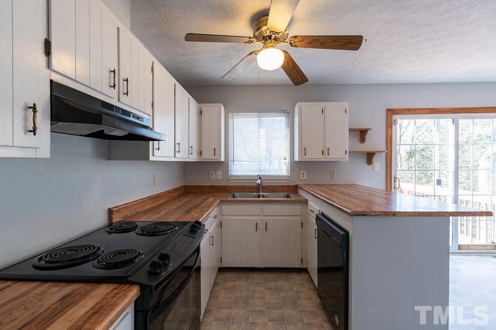 2437 Tusket Court Raleigh, NC 27613 - Photo 12 of 30 a kitchen with stainless steel appliances granite countertop a sink a stove a refrigerator and window