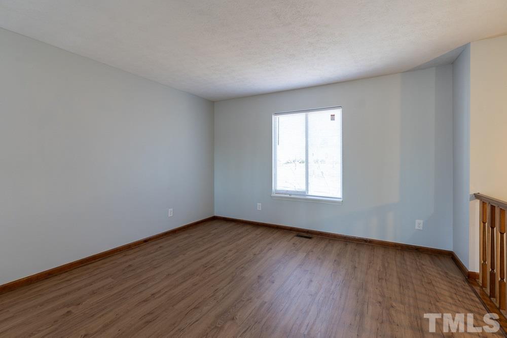 2437 Tusket Court Raleigh, NC 27613 - Photo 3 of 30 a view of an empty room with wooden floor and a window
