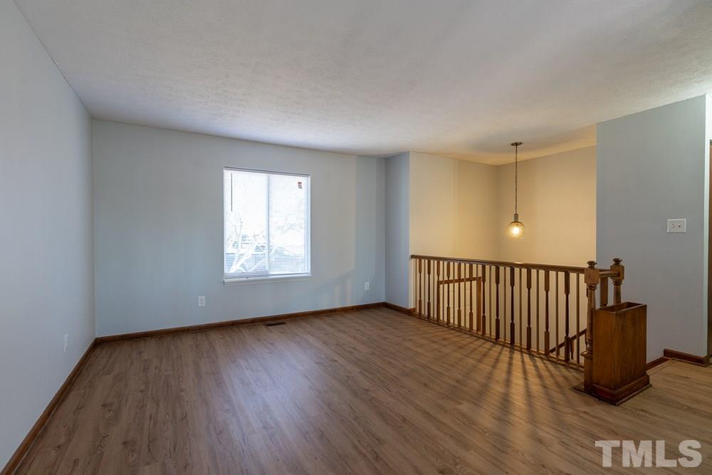 2437 Tusket Court Raleigh, NC 27613 - Photo 4 of 30 a view of an empty room with wooden floor and a window