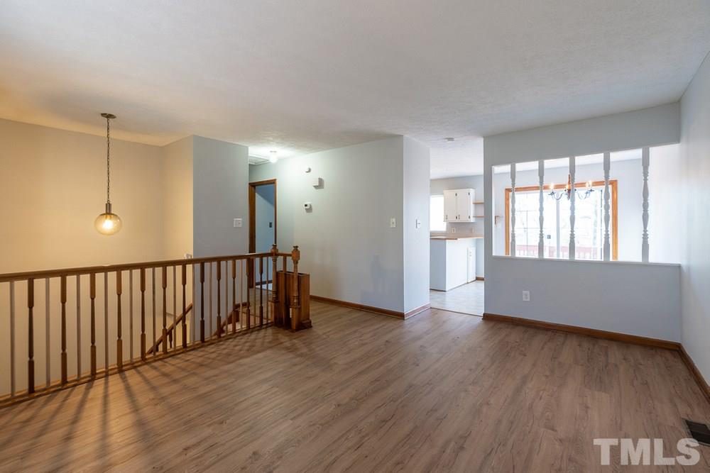 2437 Tusket Court Raleigh, NC 27613 - Photo 5 of 30 a view of an empty room with wooden floor and a window