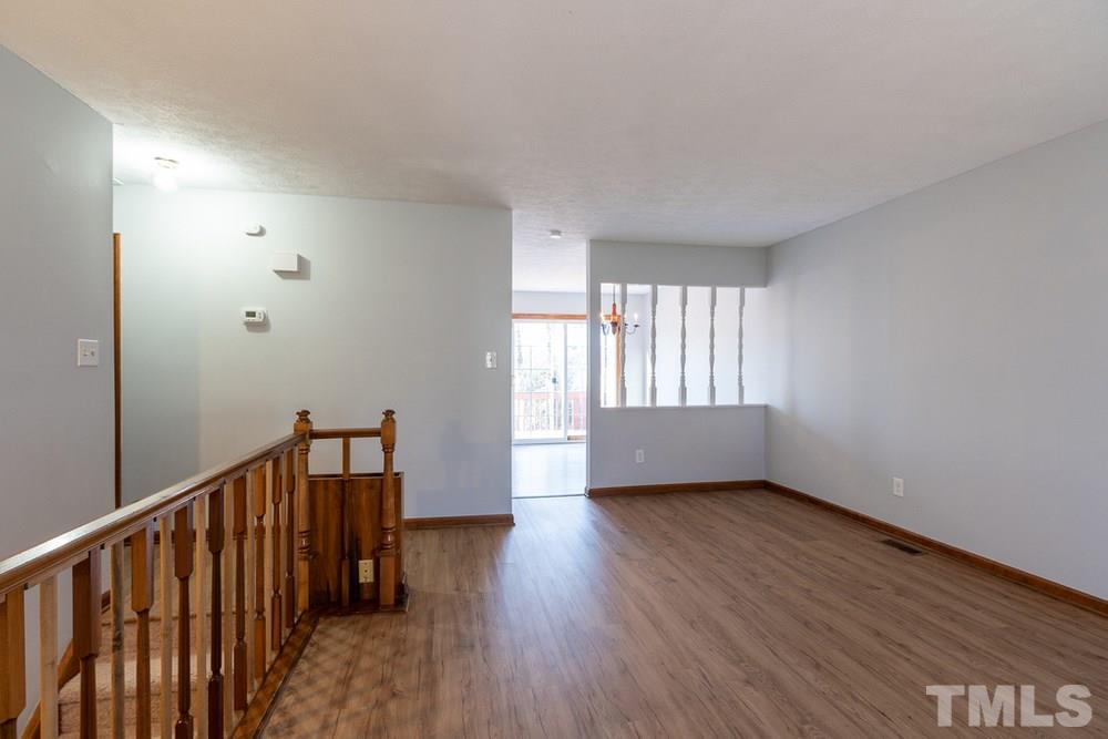 2437 Tusket Court Raleigh, NC 27613 - Photo 6 of 30 a view of an empty room with wooden floor and a window