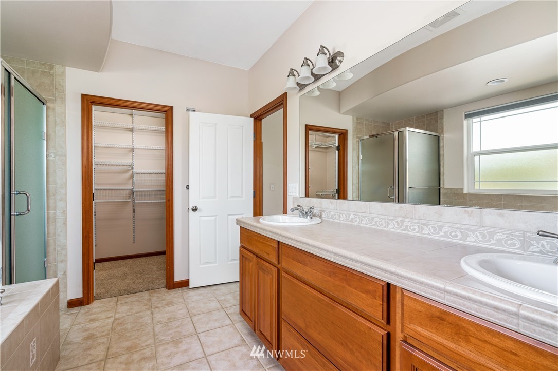 13323 Erskine Road Southwest Rochester, WA 98579 - Photo 17 of 30 a spacious bathroom with a granite countertop sink a mirror and a shower