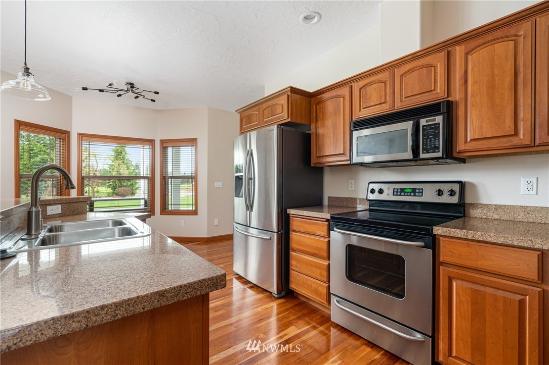 13323 Erskine Road Southwest Rochester, WA 98579 - Photo 10 of 30 a kitchen with stainless steel appliances granite countertop a stove a sink and a microwave