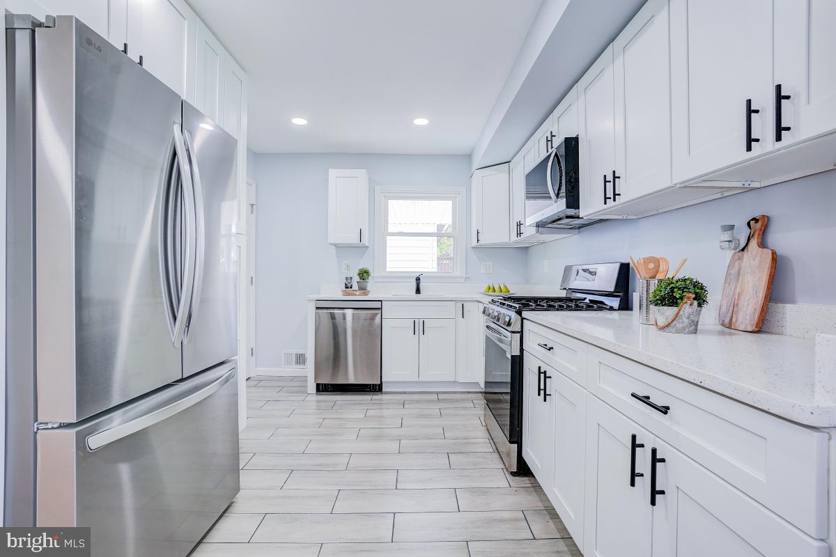 2654 Cory Terrace Silver Spring, MD 20902 - Photo 6 of 32 a kitchen with stainless steel appliances a refrigerator sink and cabinets