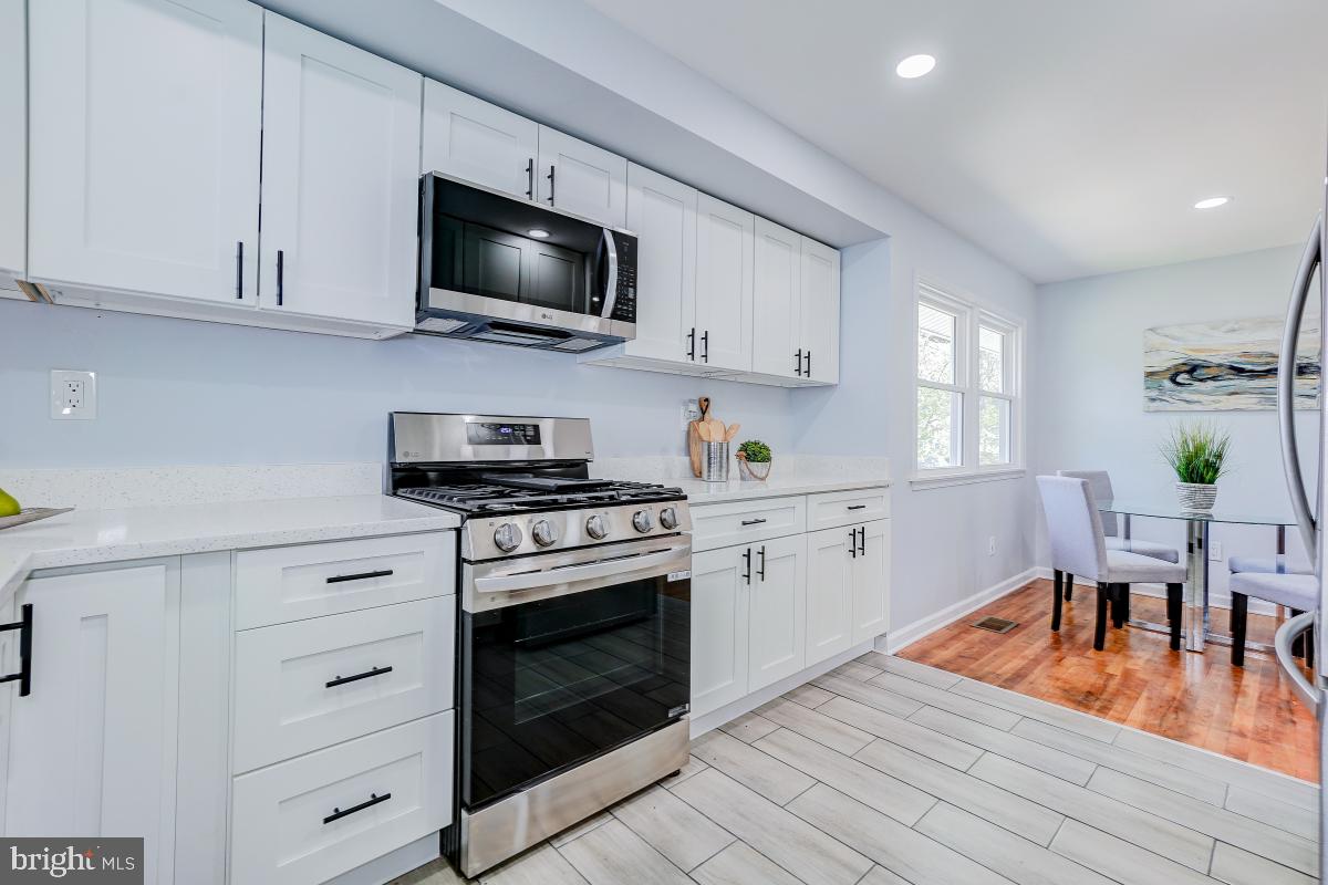2654 Cory Terrace Silver Spring, MD 20902 - Photo 8 of 32 a kitchen with stainless steel appliances granite countertop a stove a sink and a microwave