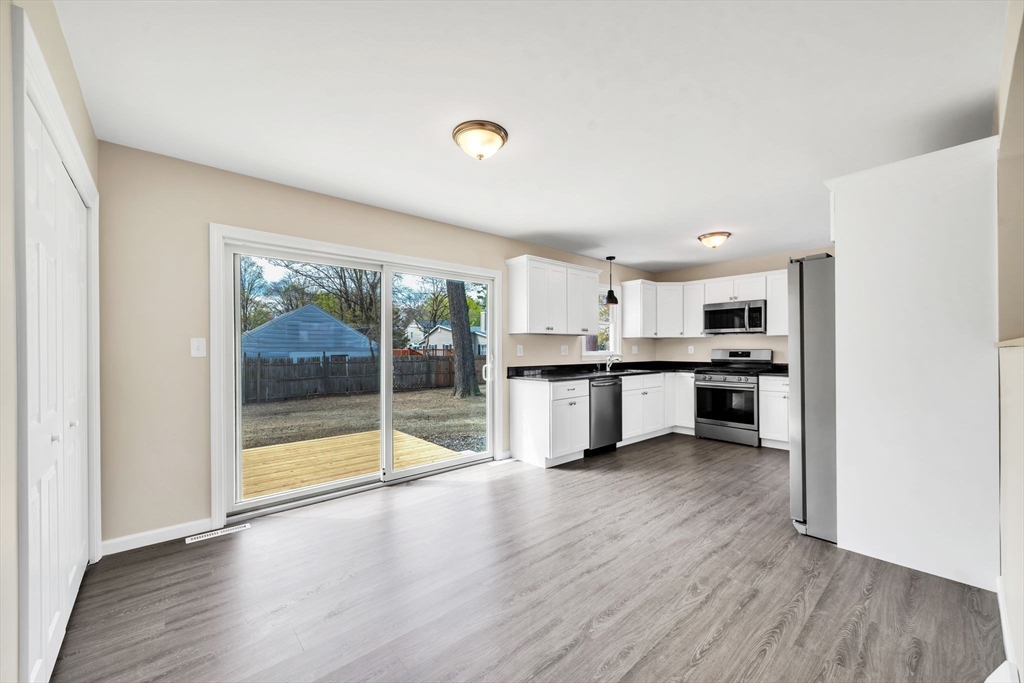 230 Gilbert Avenue Springfield, MA 01119 - Photo 11 of 40 a large kitchen with a wooden floor and windows